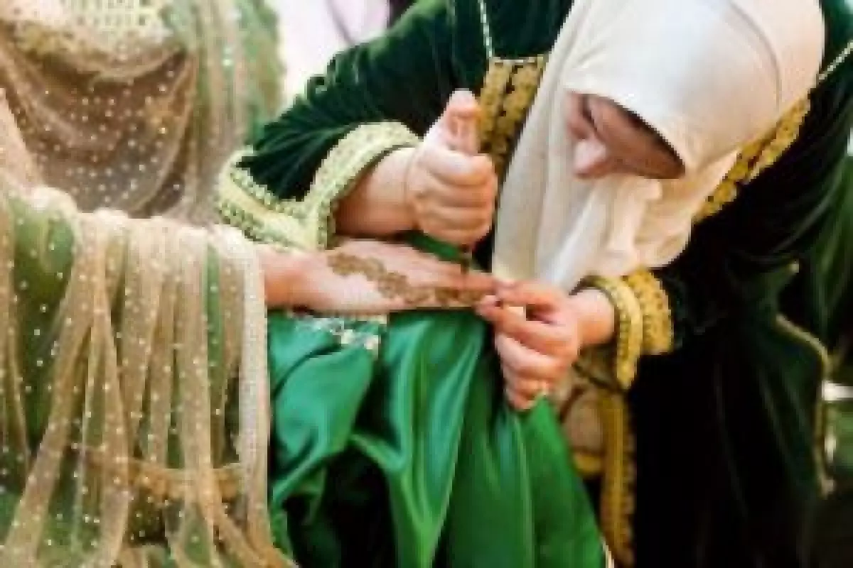 La pose du henné par la nekkacha lors de la cérémonie du henné au Maroc
